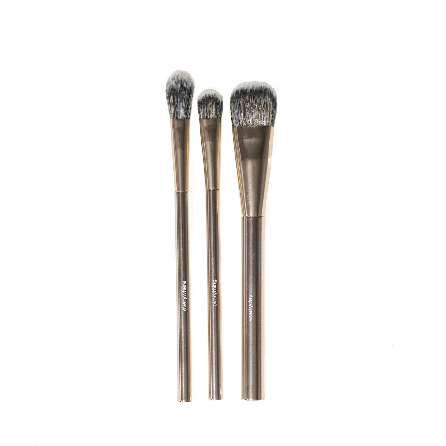 Three makeup brushes with metallic handles and gray bristles, arranged vertically on a plain white background. The handles are printed with the brush names 'EVERYWHERE' 'EVERYTHING' 'EVERYDAY'